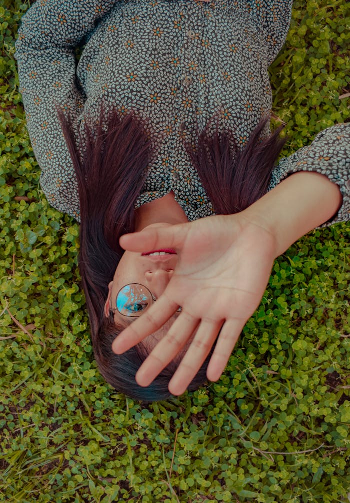 why-choose-us-img Stylish young woman lying on grass covering face with hand, showcasing outdoor fashion.